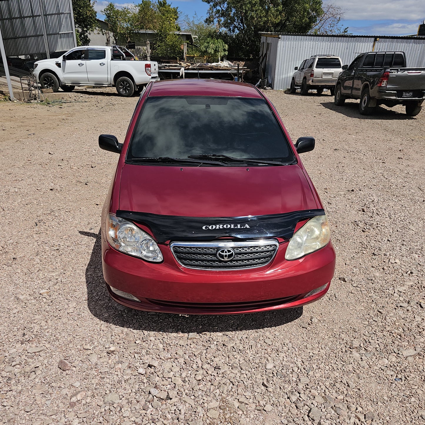 Toyota Corolla 2005 - Vista frontal parrilla y logo Toyota color rojo | Vende Tu Auto Honduras
